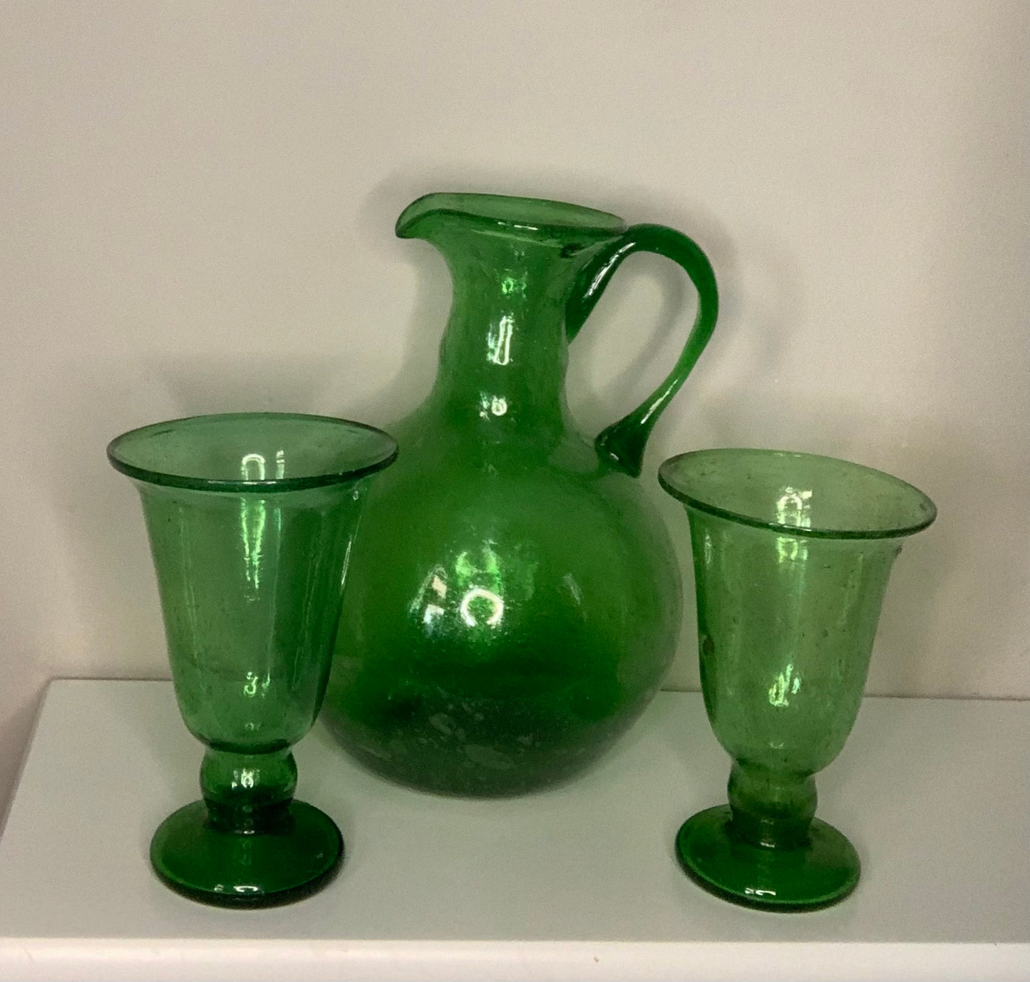 Hand-blown emerald green glass bottle decanter carafe with visible air bubbles throughout and a pontil mark, suitable for use as a vase or decorative piece.