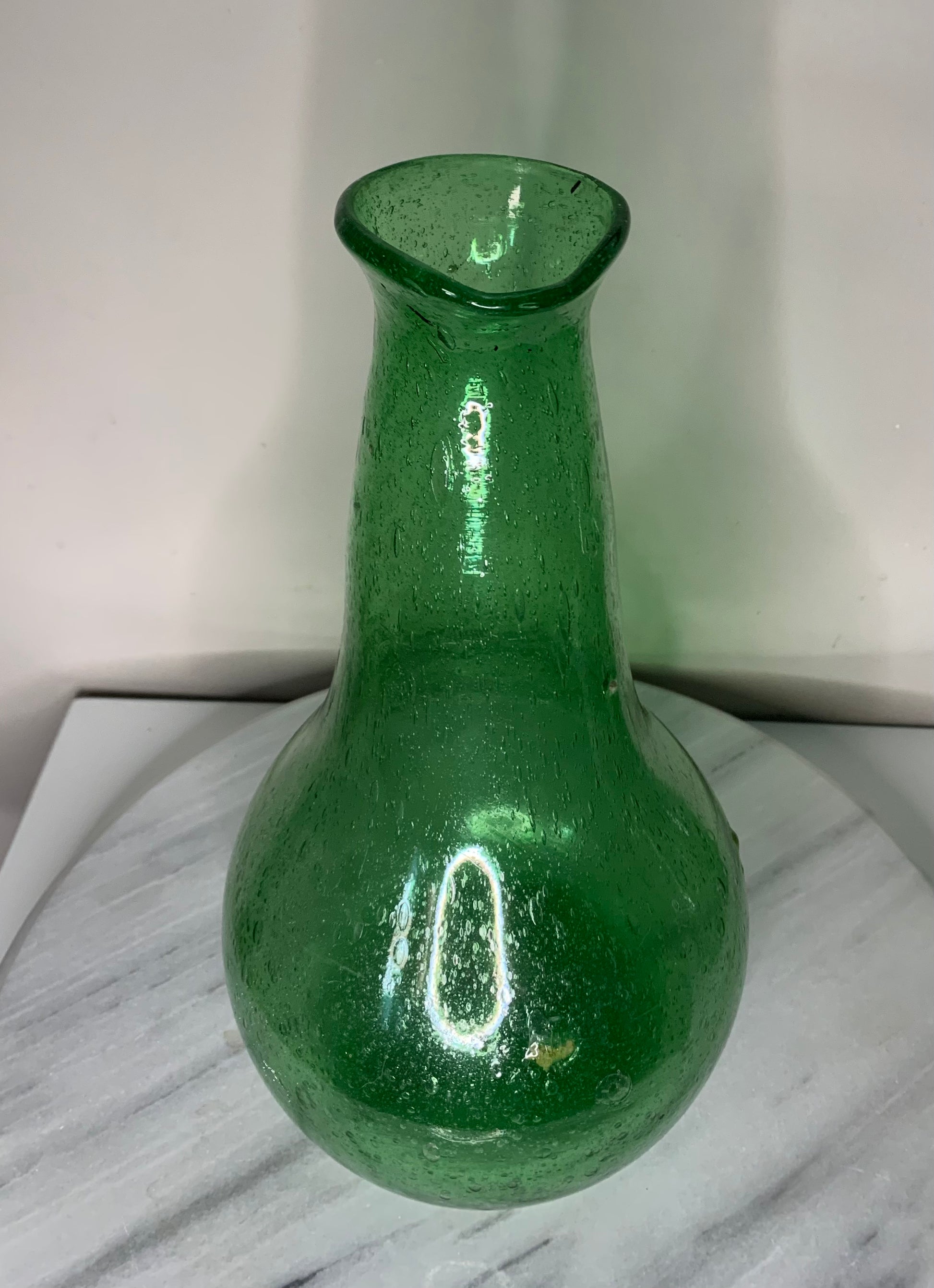 Emerald Green Bottle Decanter Carafe, hand-blown from recycled bubble glass with a characteristic pontil mark. Each piece features naturally occurring air bubbles throughout, a hallmark of the traditional glassblowing process. Beautiful as a standalone decorative object or paired with a set of recycled glasses.