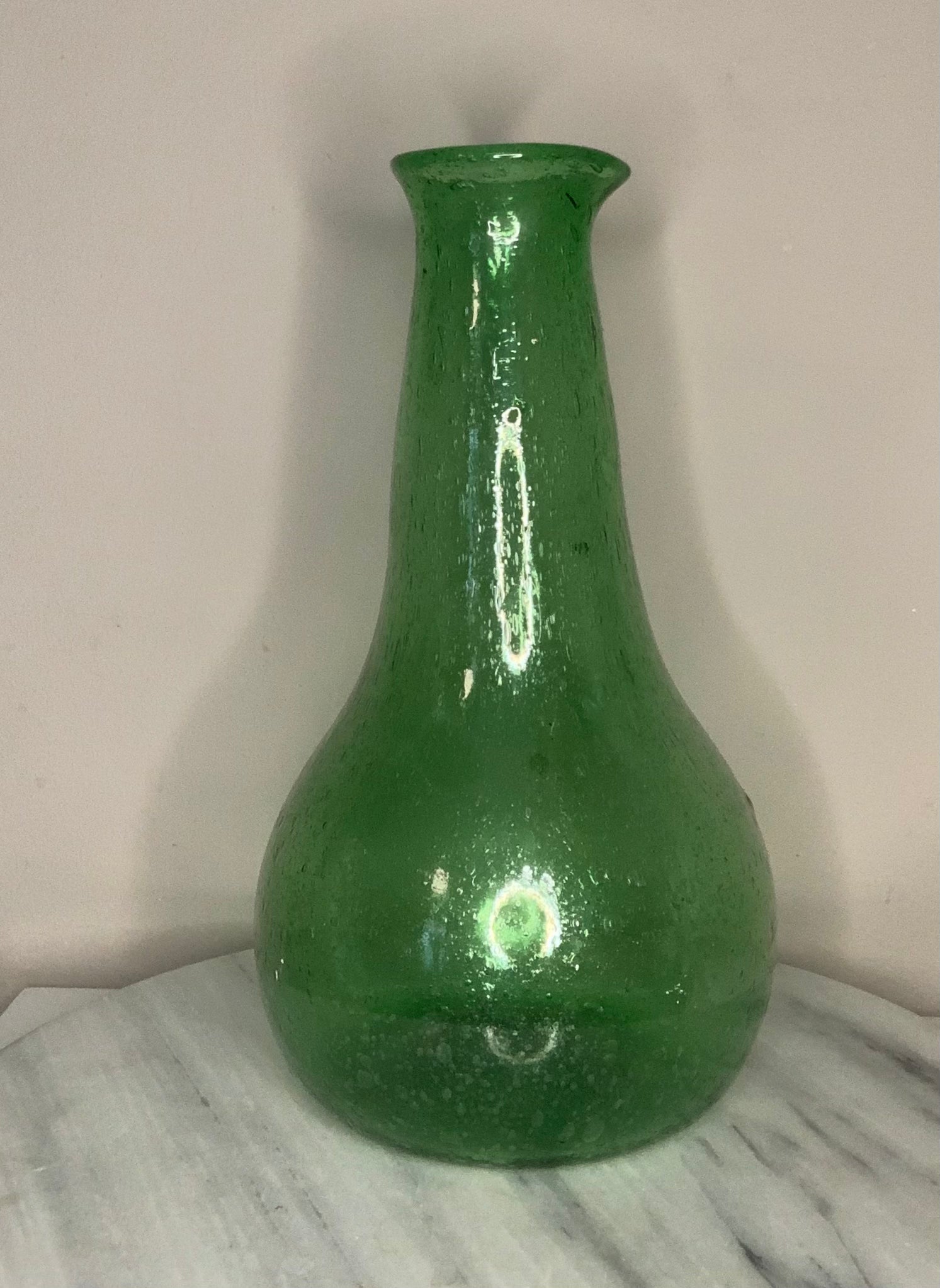 Emerald Green Bottle Decanter Carafe, hand-blown from recycled bubble glass with a characteristic pontil mark. Each piece features naturally occurring air bubbles throughout, a hallmark of the traditional glassblowing process. Beautiful as a standalone decorative object or paired with a set of recycled glasses.