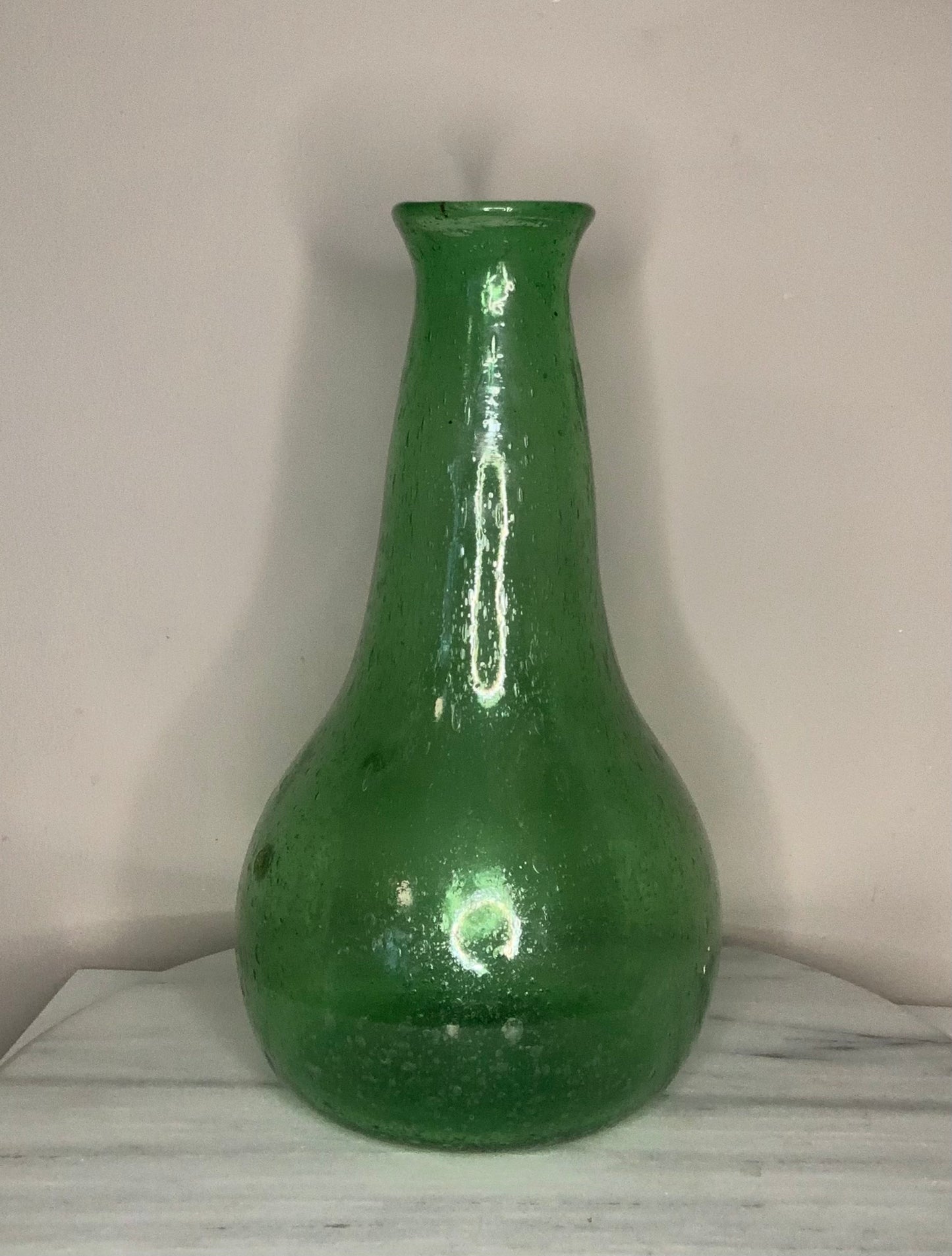 Emerald Green Bottle Decanter Carafe, hand-blown from recycled bubble glass with a characteristic pontil mark. Each piece features naturally occurring air bubbles throughout, a hallmark of the traditional glassblowing process. Beautiful as a standalone decorative object or paired with a set of recycled glasses.