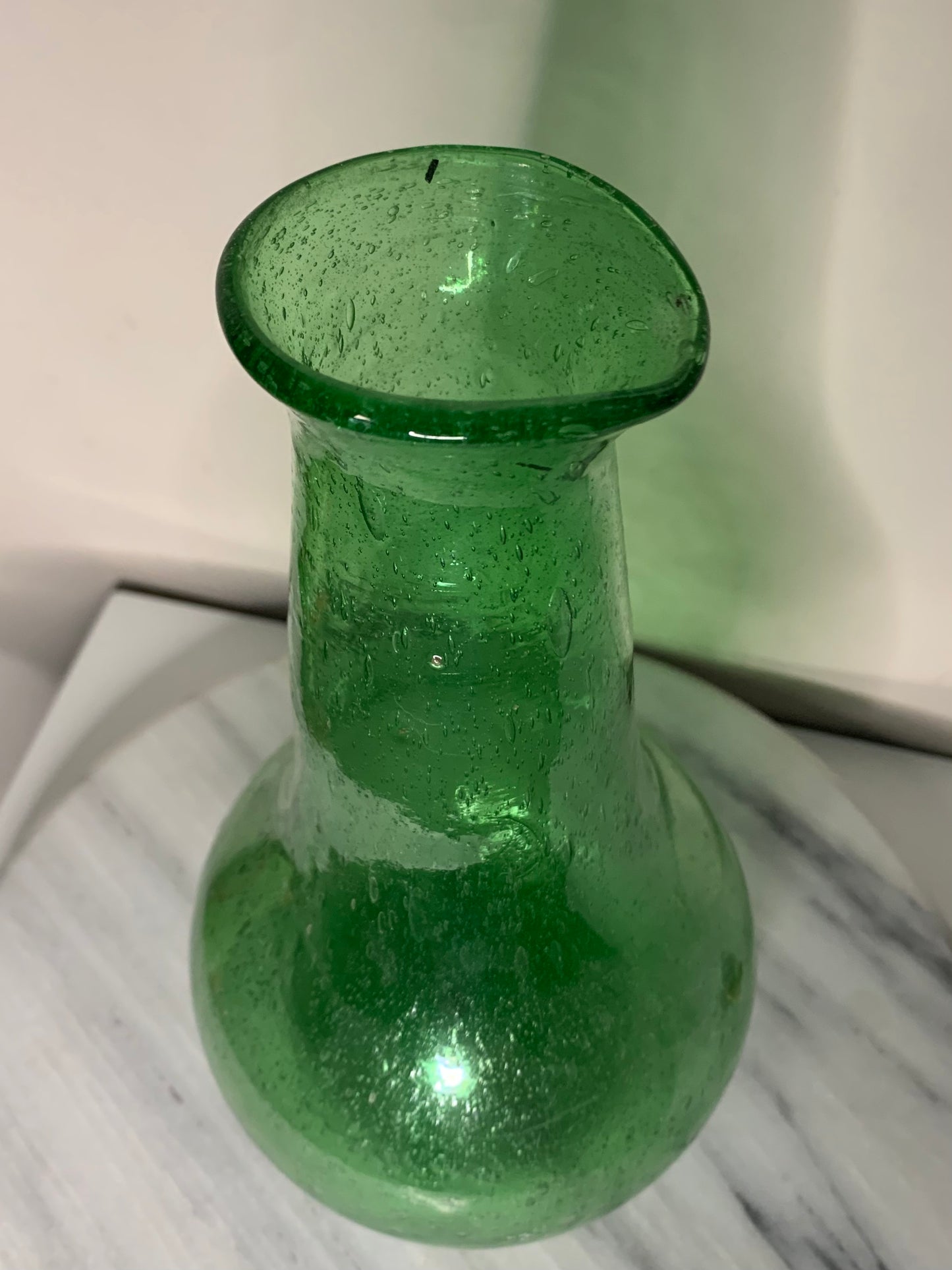 Emerald Green Bottle Decanter Carafe, hand-blown from recycled bubble glass with a characteristic pontil mark. Each piece features naturally occurring air bubbles throughout, a hallmark of the traditional glassblowing process. Beautiful as a standalone decorative object or paired with a set of recycled glasses.