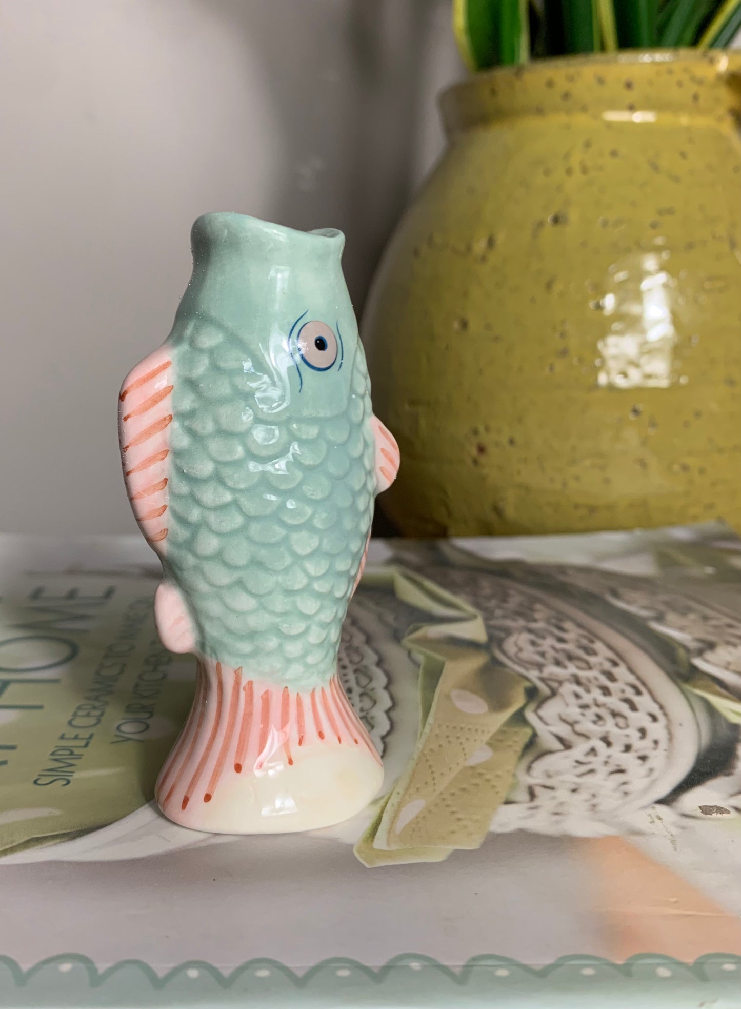 Small ceramic fish-shaped bud vase in mint green and coral/pink, glaze finish,