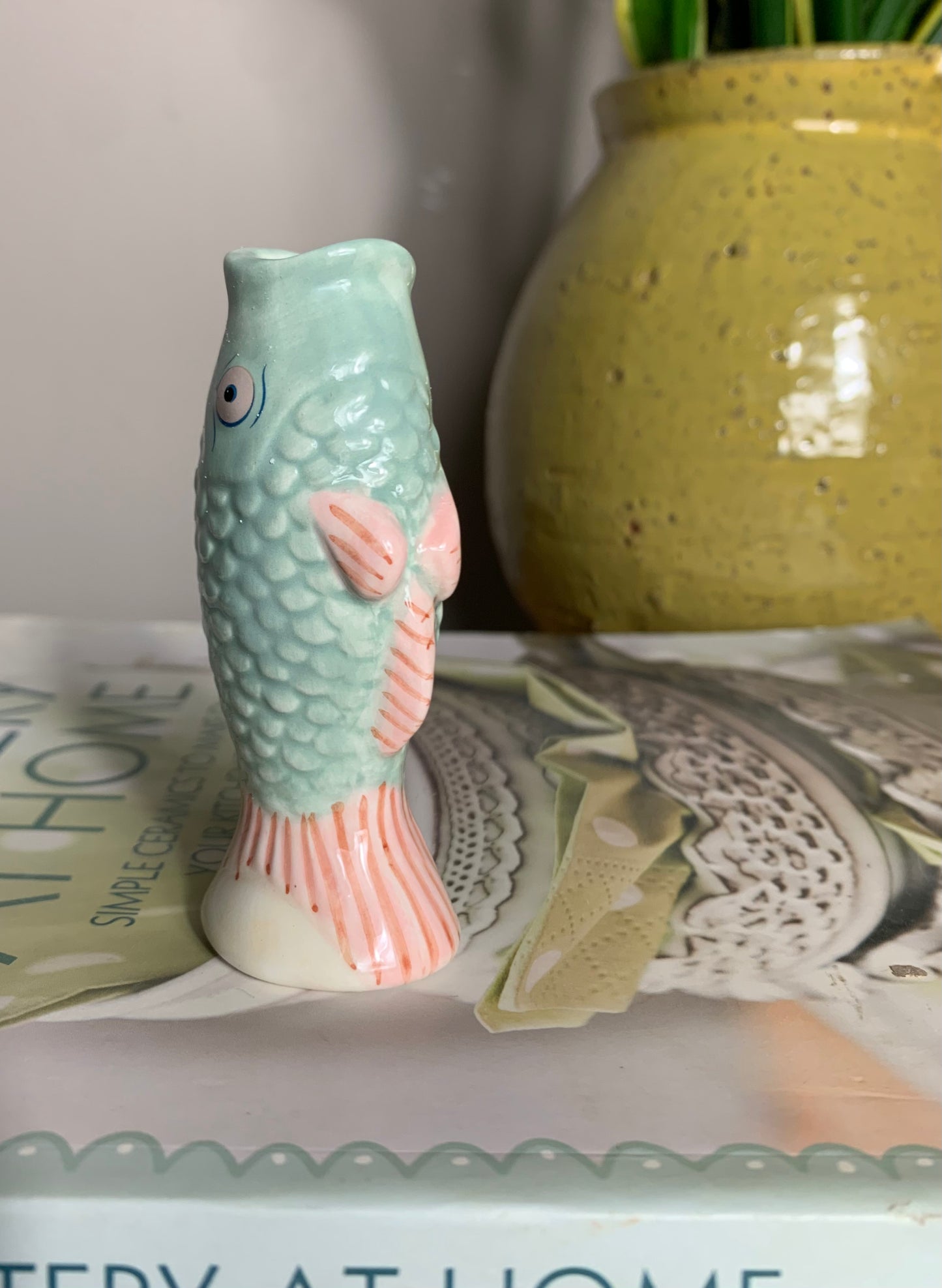 Small ceramic fish-shaped bud vase in mint green and coral/pink, glaze finish,