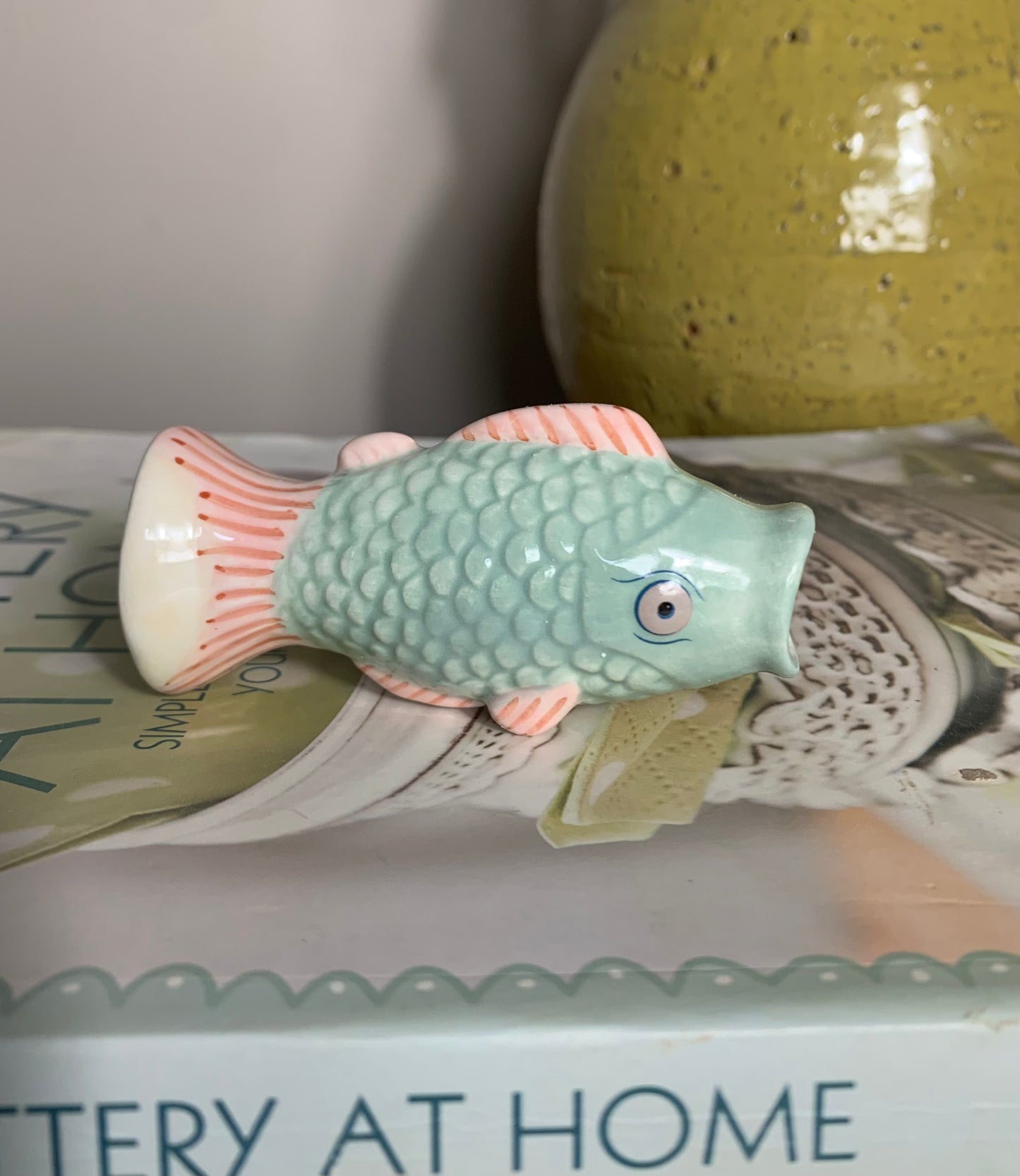 Small ceramic fish-shaped bud vase in mint green and coral/pink, glaze finish,