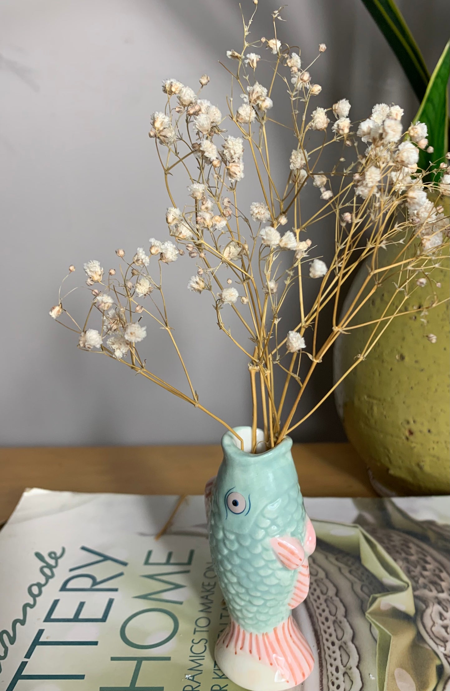 Small ceramic fish-shaped bud vase in mint green and coral/pink, glaze finish,