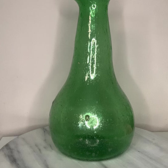 Emerald Green Bottle Decanter Carafe, hand-blown from recycled bubble glass with a characteristic pontil mark. Each piece features naturally occurring air bubbles throughout, a hallmark of the traditional glassblowing process. Beautiful as a standalone decorative object or paired with a set of recycled glasses.